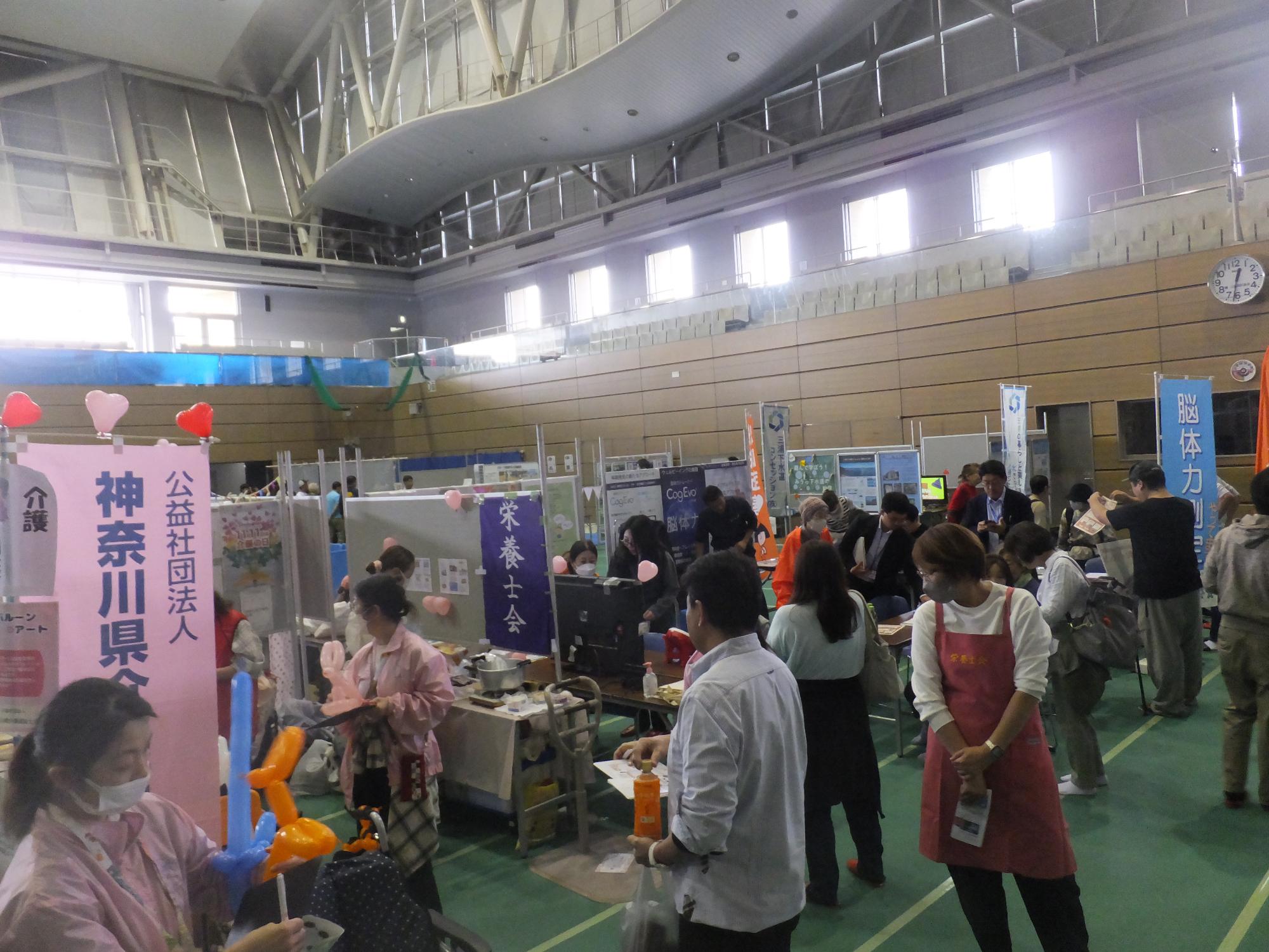 アリーナ内部の市民団体などの展示と来場者の写真