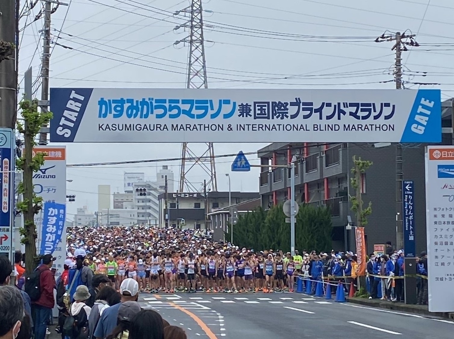 かすみがうらマラソン兼国際ブラインドマラソンと書かれたゲート前で大勢のランナーがスタートを待つ写真