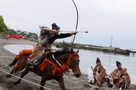 馬上にまたがり弓を射っている、道寸祭りの笠懸の写真