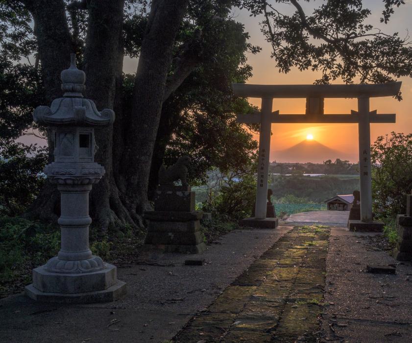 鳥居の奥に見える富士山と夕日の画像