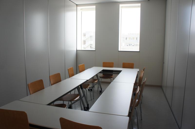 四角に囲んだテーブルに椅子が12個ある比較的小さ目の研修室の写真