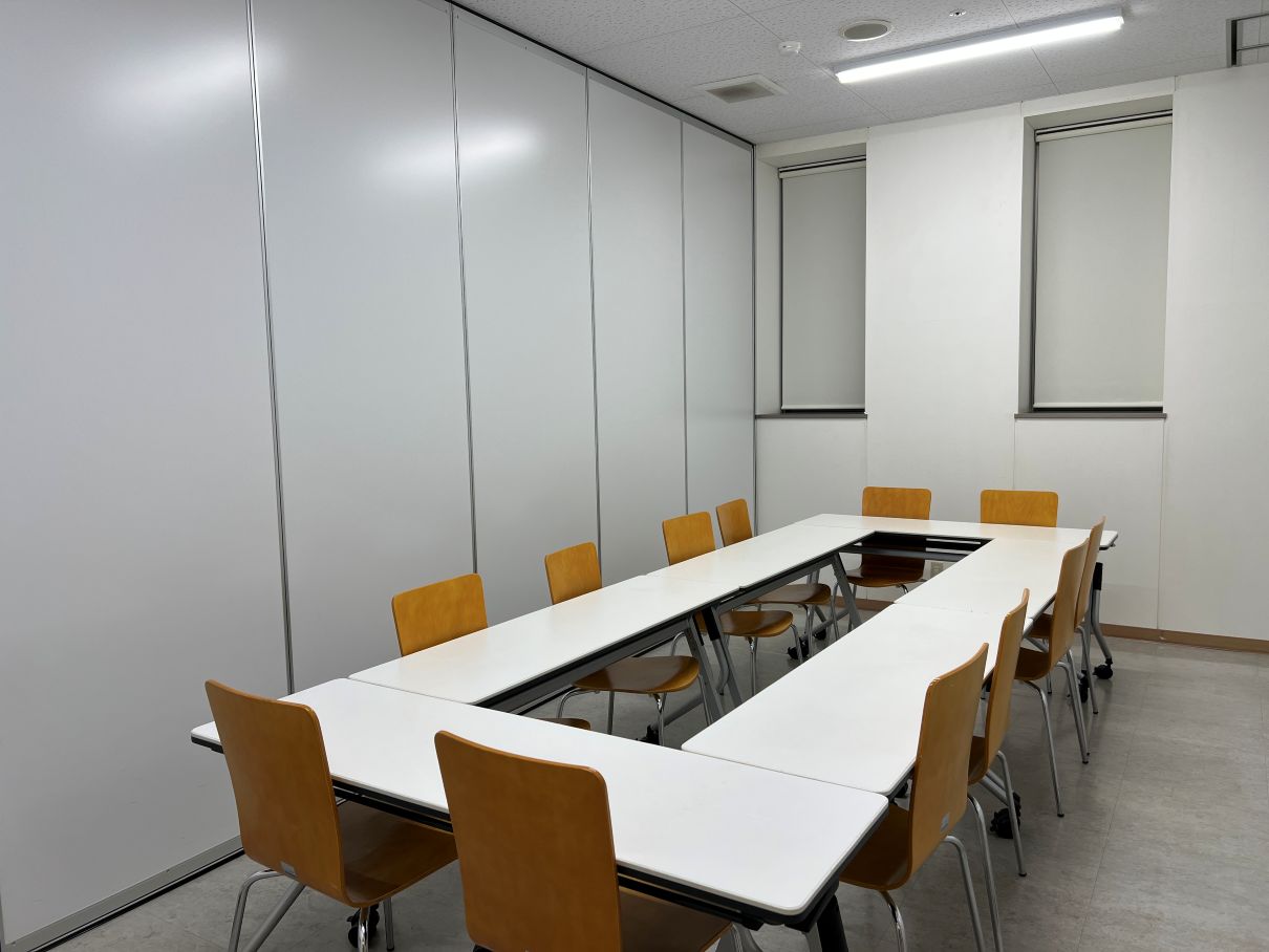 四角に囲んだテーブルに椅子が12個ある比較的小さ目の研修室の写真