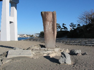 晴天の砂浜の上に大きな石碑が建てられている写真