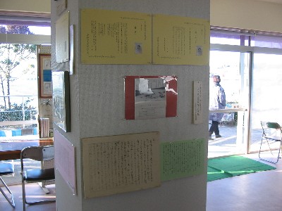 柱の一つの面に、写真や書簡などの資料が並べて展示されている写真
