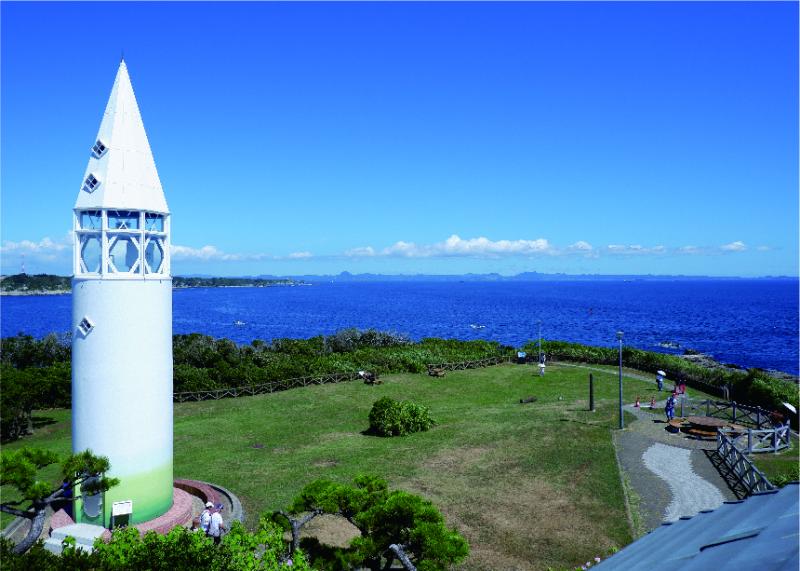 青い海を見渡すように建っている白い灯台の写真