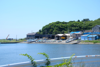 浜のそばで小屋やボートが複数並んでいる写真