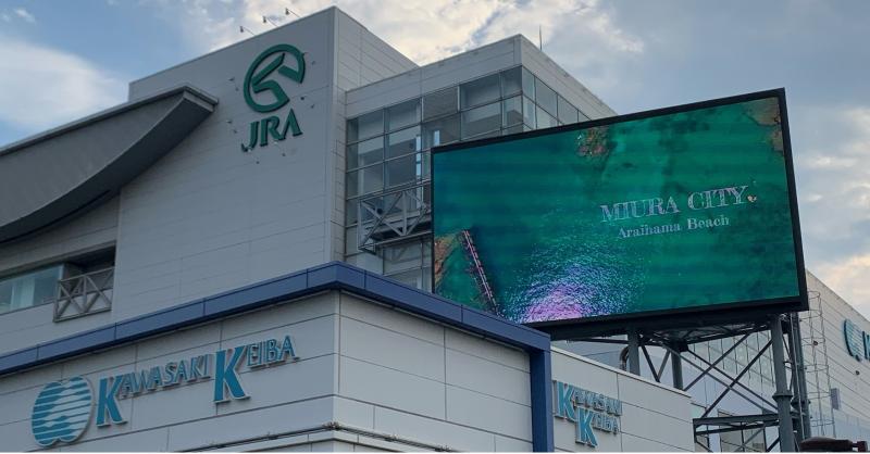 川崎競馬場の外観と広告用の電光掲示板が並んでいる写真