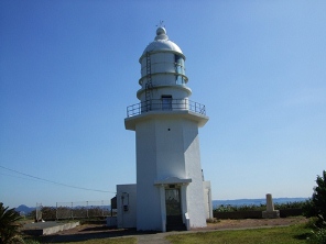 青空と海を背に、白い灯台が建っている写真