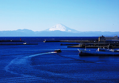 A photo of a boat sailing on the blue sea with Mt. Fuji in the background