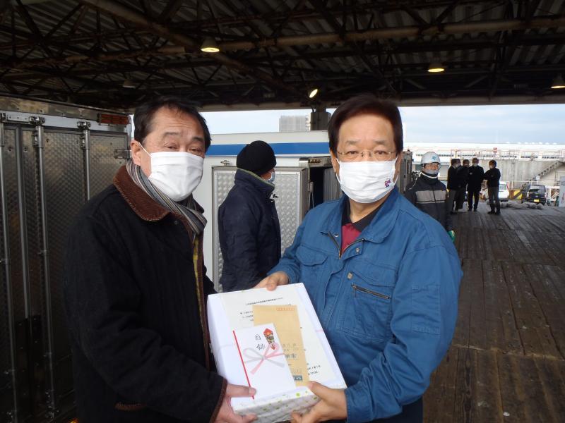 第1勝運丸船主と三浦市長が記念品を持ってこちらへ向けている写真