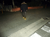 夜道を歩く人の靴の踵に貼った見守りシールが光に反射して光っている様子を写した写真