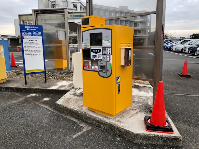 駐車場の出口に設置された黄色い精算機の写真
