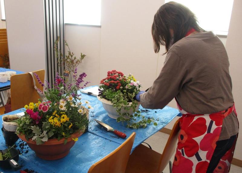 寄せ植え教室で参加者が植物の作品を作っている写真