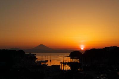奥に富士山の影が見える夕暮れの諸磯湾の写真
