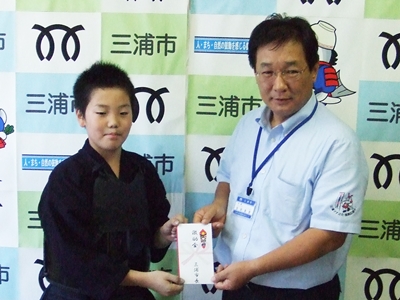 剣道で優勝した新倉大輝さんが、渡された賞を手にしている写真