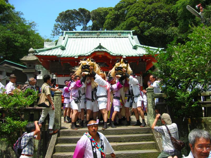 神社の前で神輿を担いでいる人たちの写真