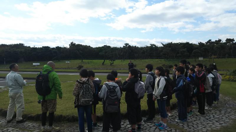 青空のもと、神奈川県立城ケ島公園で輪を囲んでいる子供たちの写真