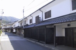 白い外壁に瓦屋根の蔵の街並みが街道沿いに続いている写真