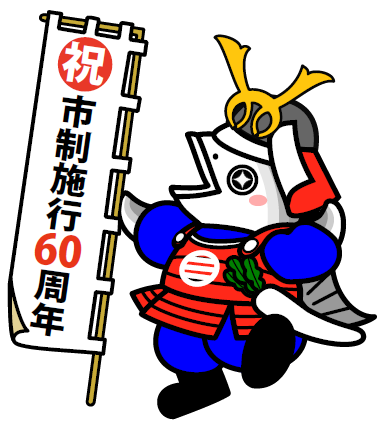「祝市制施行60周年」と書かれた幟を持ち鎧を着た魚のキャラクター「三浦ツナ之介」の写真